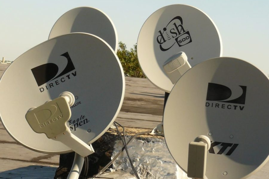 DirecTV satellite dish mounted on a building — ready for professional removal